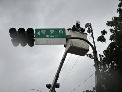 新北市交通局交通號誌維修小組今（9 日）冒著風雨，搶修交通號誌排除故障